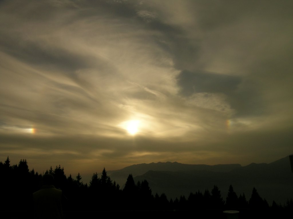 Parelio ripreso dal Monte Zugna nel novembre 2004. I parelii (dal greco parà, vicino, ed élios, sole) sono punti di luce che appaiono intorno al Sole. Sono causati dal riflesso della luce solare attraverso gocce d'acqua presenti in sospensione nell'aria. (foto Ochner)